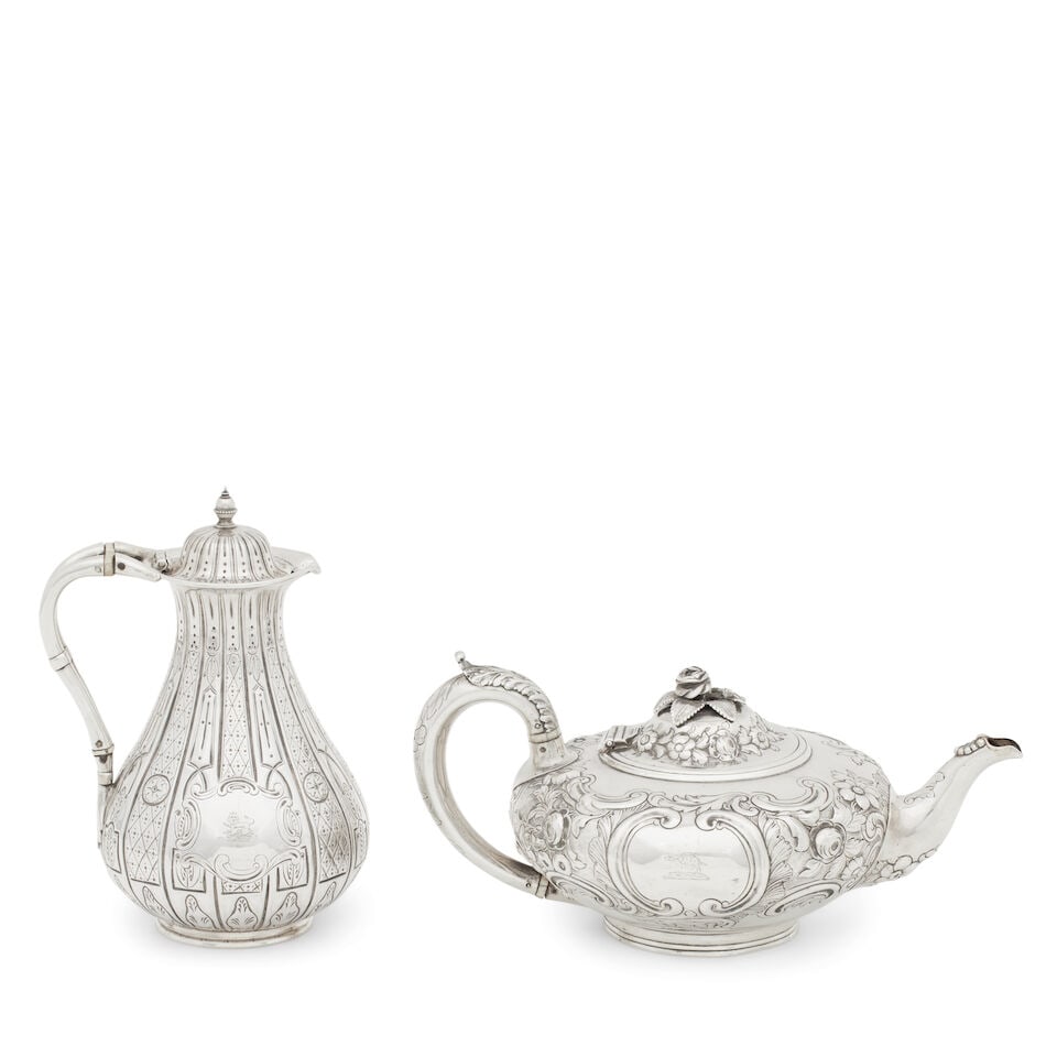 A Victorian silver teapot William Wrangham Williams, London, 1866 (2): A Victorian silver teapot William Wrangham Williams, London, 1866 of compressed form, embossed and chased with scrolls and flowers and centred by a cartouche engraved with a crest, with leaf capped ha