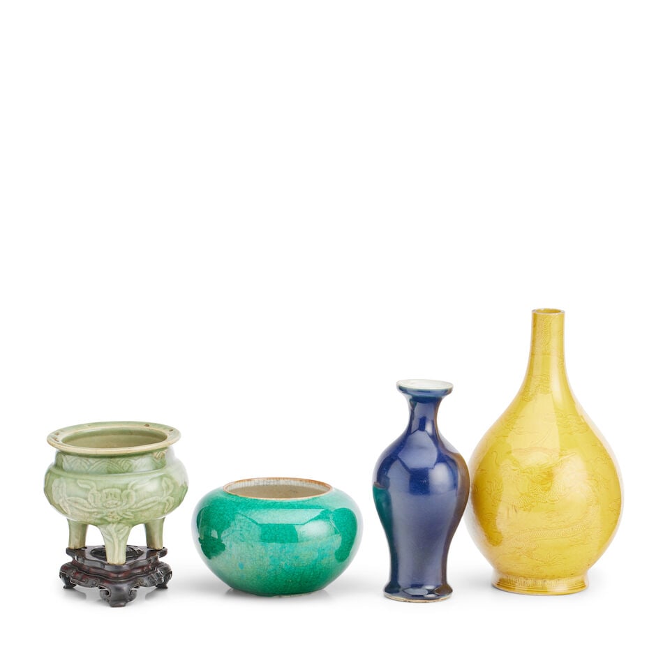 A Chinese celadon censer Ming (4): A Chinese celadon censer Ming The tripod vessel inspired by a bronze prototype, moulded in relief with stylized peony and with everted rim, 11.7cm high, later wooden stand, a yellow glazed bottle vase