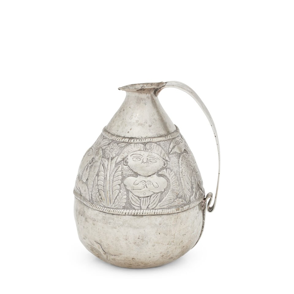 A Spanish Colonial silver jug 19th Century Unmarked: A Spanish Colonial silver jug 19th Century Unmarked Of pear shape and decorated with a band of embossed and chased indigenous figures and birds, with strap handle, height 21.1cm, weight 22oz. For furt