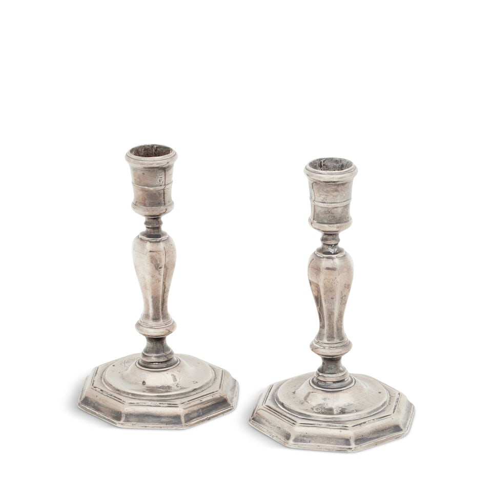 A pair of George I Irish silver candlesticks Maker's mark illegible, Dublin, 1725: A pair of George I Irish silver candlesticks Maker's mark illegible, Dublin, 1725 each with octagonal base and baluster column with cylindrical socket, engraved with a lady's coat of arms, engraved un