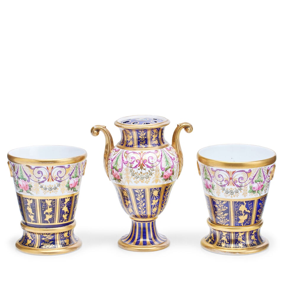 A Regency gilt porcelain three-piece garniture: A Regency gilt porcelain three-piece garniture Comprising a two-handled pot pourri, of inverted pear shape with pierced cover and a pair of cachepot on stands, each having a broad band of roses, scrol