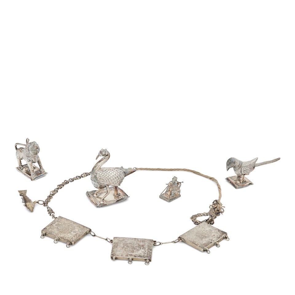 Three Indian silver models 19th Century (6): Three Indian silver models 19th Century Depicting a water bird, a lion and a parrot, each naively modelled, standing on a rectangular base, unmarked, the first 8.5cm high, a miniature model of a man s