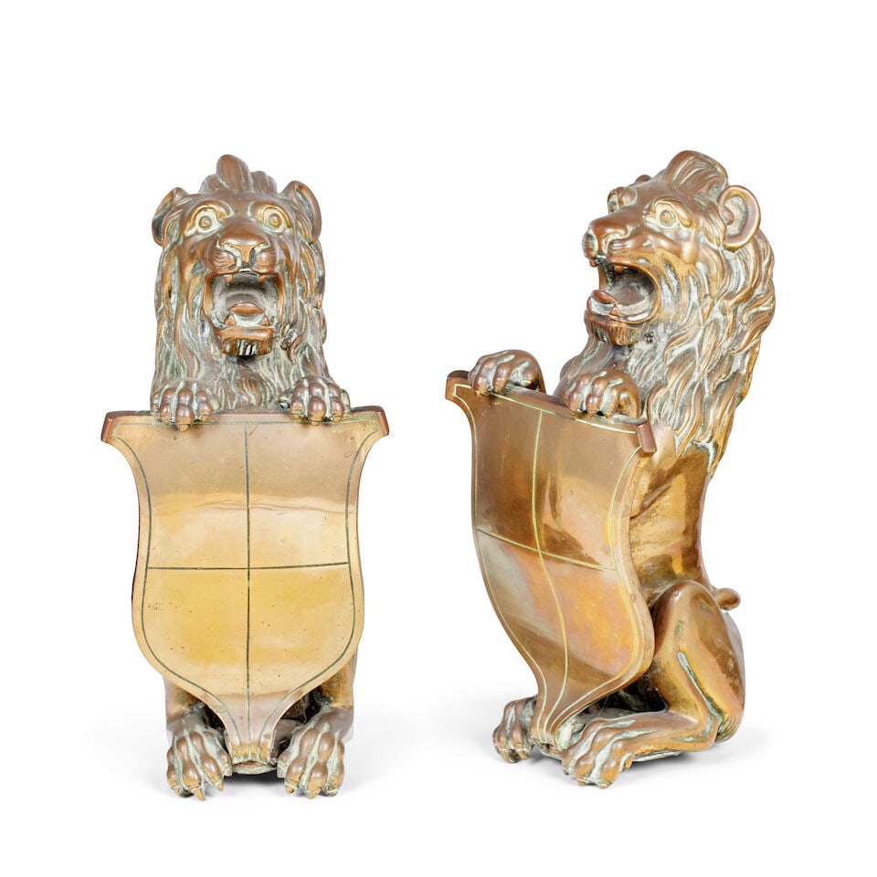 A pair of bronze heraldic lions, 19th century (2): A pair of bronze heraldic lions, 19th century Both standing upright holding a shield with their front paws, 13cm wide, 12cm deep, 28cm high (5in wide, 4 1/2in deep, 11in high) (2) For further informat