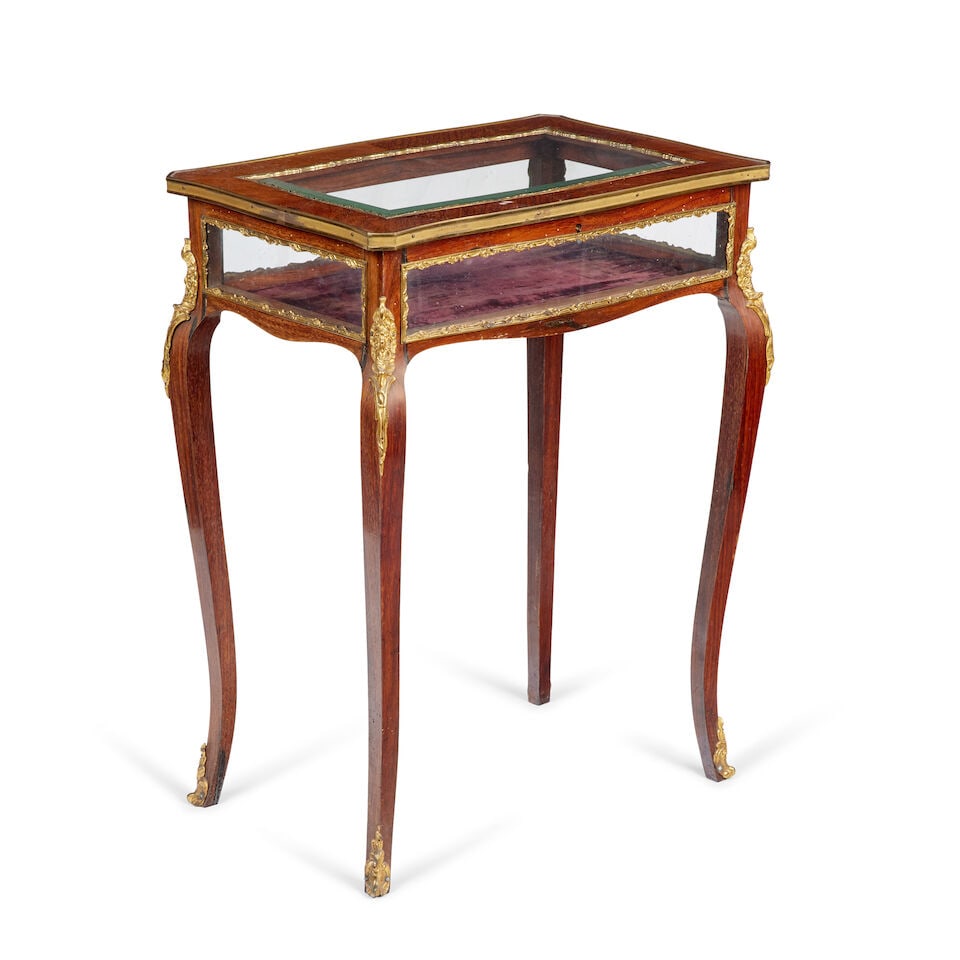 A late 19th century ormolu mounted kingwood and rosewood table vitrine: A late 19th century ormolu mounted kingwood and rosewood table vitrine The Shaped top enclosing an interior lined in purple fabric, raised on outwept legs, 61cm wide, 41cm deep, 71cm high (24in wide,