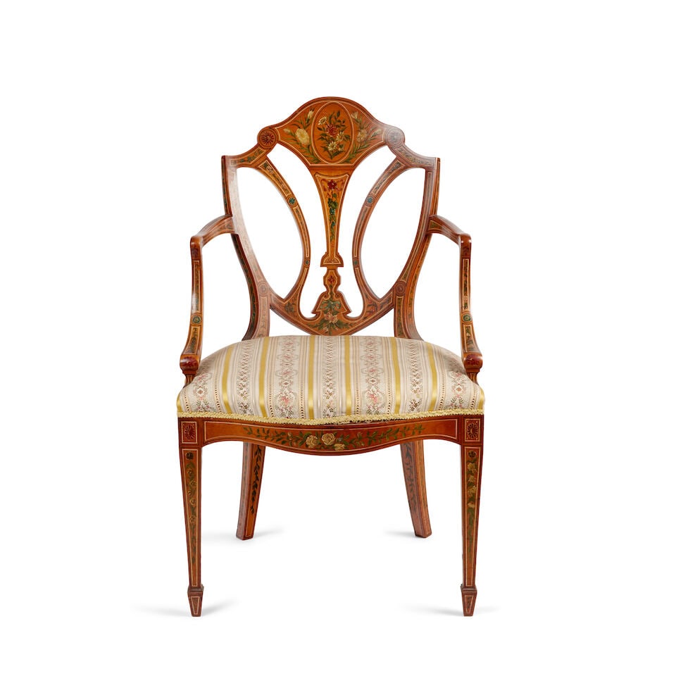 A Sheraton revival satinwood and polychrome decorated armchair, late 19th/early 20th century: A Sheraton revival satinwood and polychrome decorated armchair, late 19th/early 20th century Decorated with flowers and foliage, the shield shaped back with an open vertical splats, above an