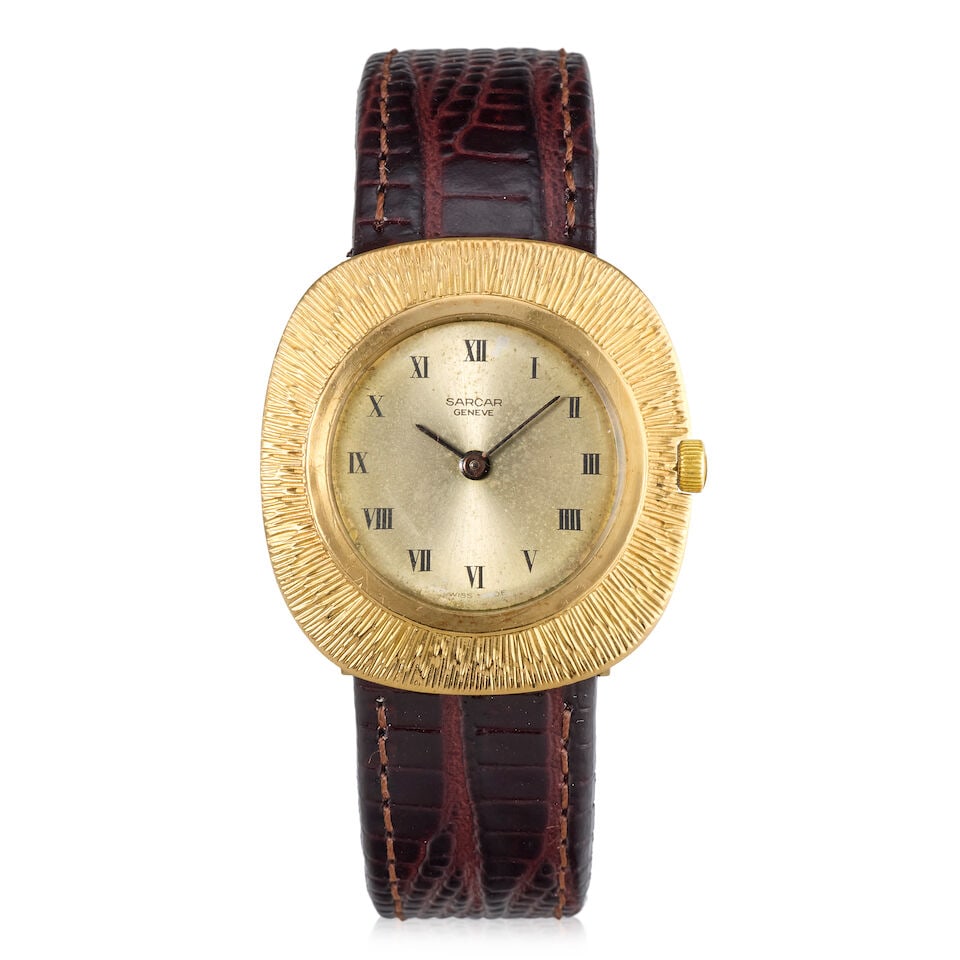 Sarcar. An 18K gold manual wind wristwatch Circa 1970: Sarcar. An 18K gold manual wind wristwatch Date: Circa 1970 Movement: 17-jewel manual wind Dial: Sunburst champagne, Roman numerals in black Case: Engraved flat cushion-shaped,