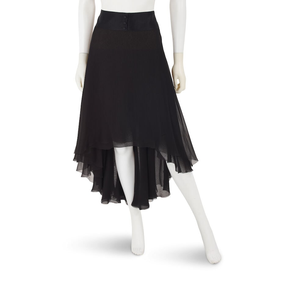 CHANEL: BLACK CHIFFON TIERED HIGH LOW SKIRT Fall 2004: CHANEL: BLACK CHIFFON TIERED HIGH LOW SKIRT Fall 2004 • Black Silk Chiffon Tiered Exterior • Crystal Embellished CC Buttons on Front of Waistband • Zip Closure • Marked Size 40