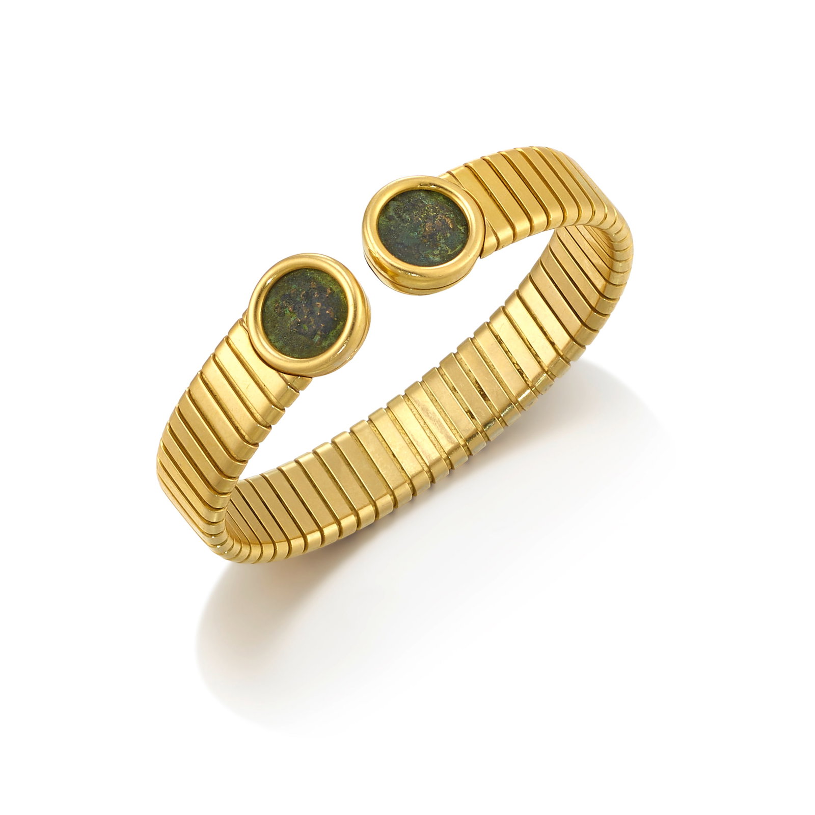 BULGARI: AN 18K GOLD 'MONETE' BRACELET: BULGARI: AN 18K GOLD 'MONETE' BRACELET A tubogas cuff, the terminals accented with ancient coins from the city of Selge in Pisidia (Turkey), 2nd century BCE; signed Bulgari; with registered Italian tr