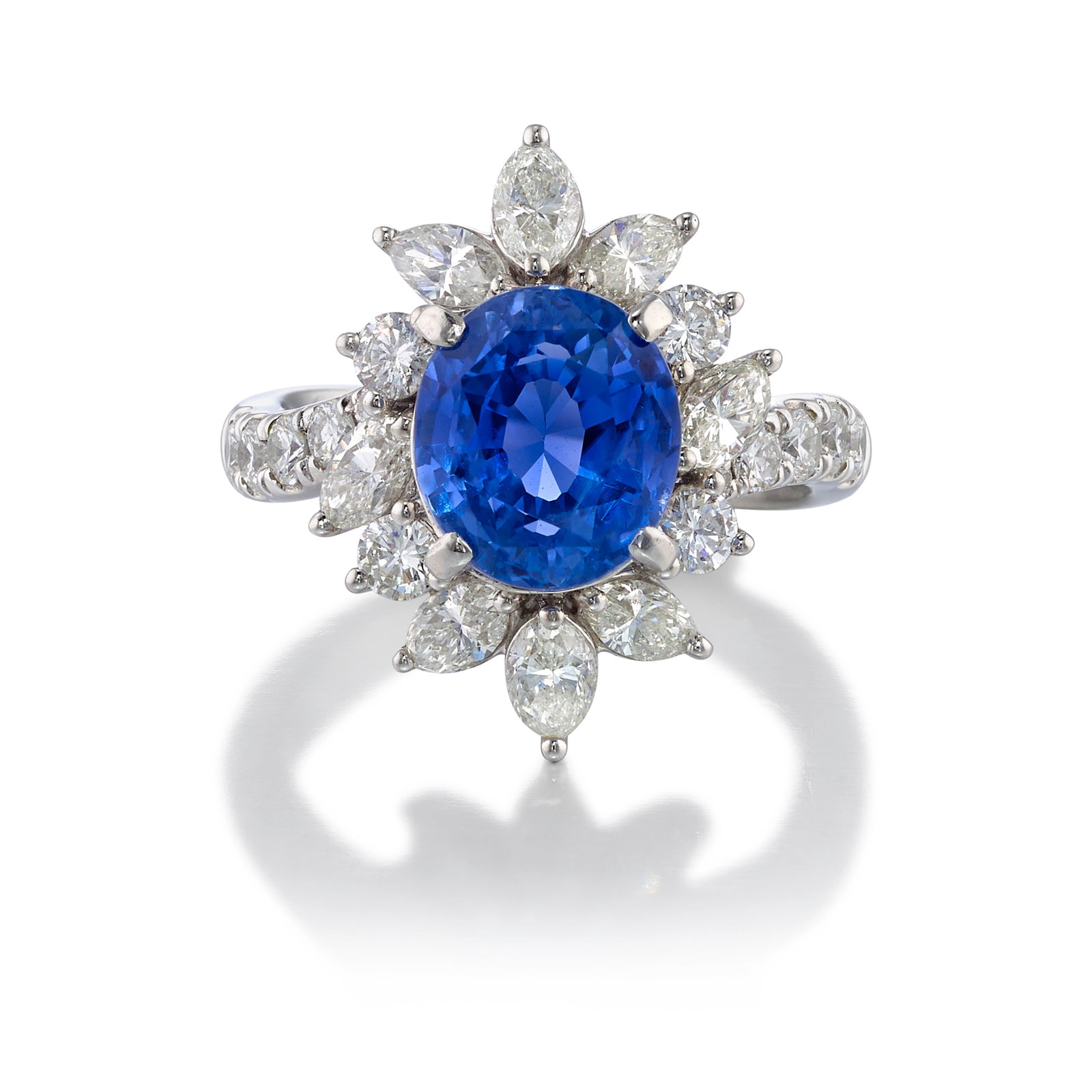 A PLATINUM, SAPPHIRE AND DIAMOND RING: A PLATINUM, SAPPHIRE AND DIAMOND RING Centering an oval-shaped sapphire, in a cluster surround of round brilliant-cut and marquise-shaped diamonds; estimated sapphire weight 5.80 carats; estimated