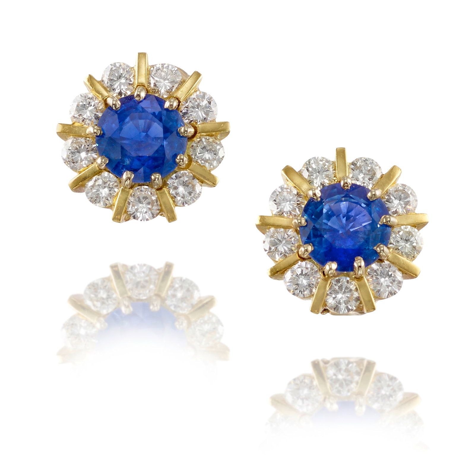 A PAIR OF SAPPHIRE AND DIAMOND EARCLIPS: A PAIR OF SAPPHIRE AND DIAMOND EARCLIPS Each centering a round sapphire, in surrounds of round brilliant-cut diamonds; estimated total sapphire weight 5.40 carats; estimated total diamond weight 2.70