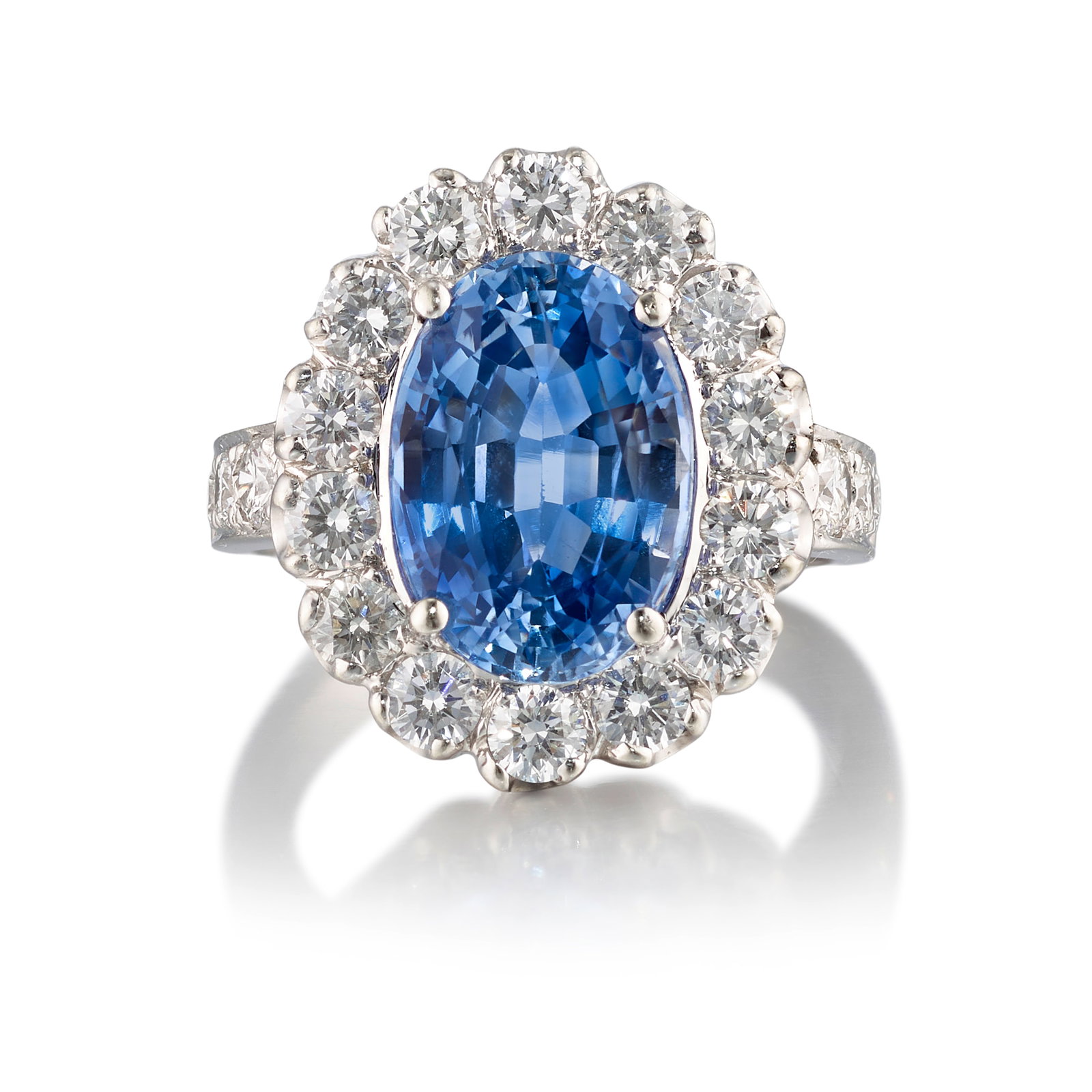 AN 18K WHITE GOLD, SAPPHIRE AND DIAMOND RING: AN 18K WHITE GOLD, SAPPHIRE AND DIAMOND RING Centering an oval-shaped sapphire, in a surround of round brilliant-cut diamonds; estimated sapphire weight 5.00 carats; estimated total diamond weight