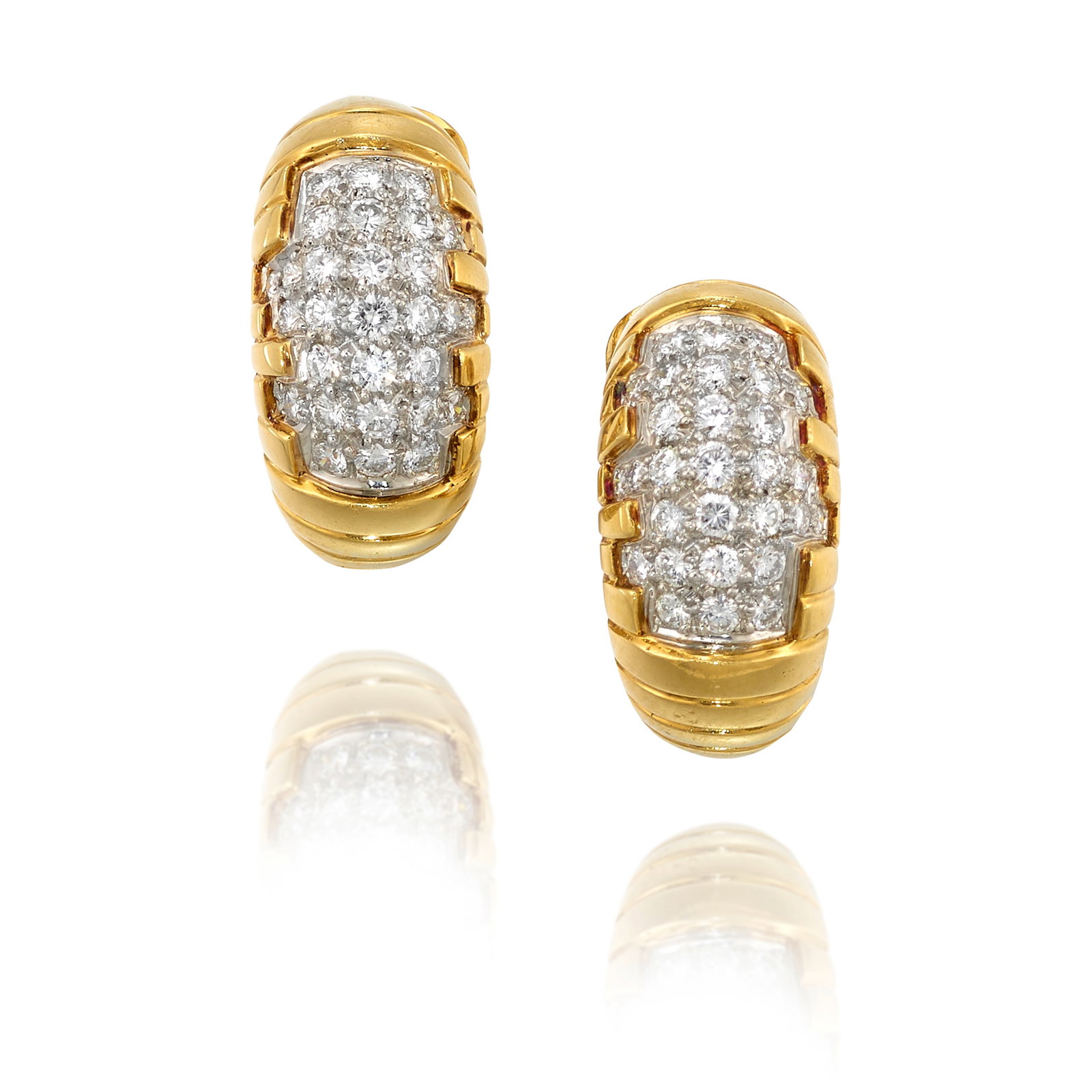 A PAIR OF 18K BICOLOR GOLD AND DIAMOND EARCLIPS: A PAIR OF 18K BICOLOR GOLD AND DIAMOND EARCLIPS Accented with round brilliant-cut diamonds, pavé-set in white gold; estimated total diamond weight 0.90 carat; measures 15/16 x 7/16 in.