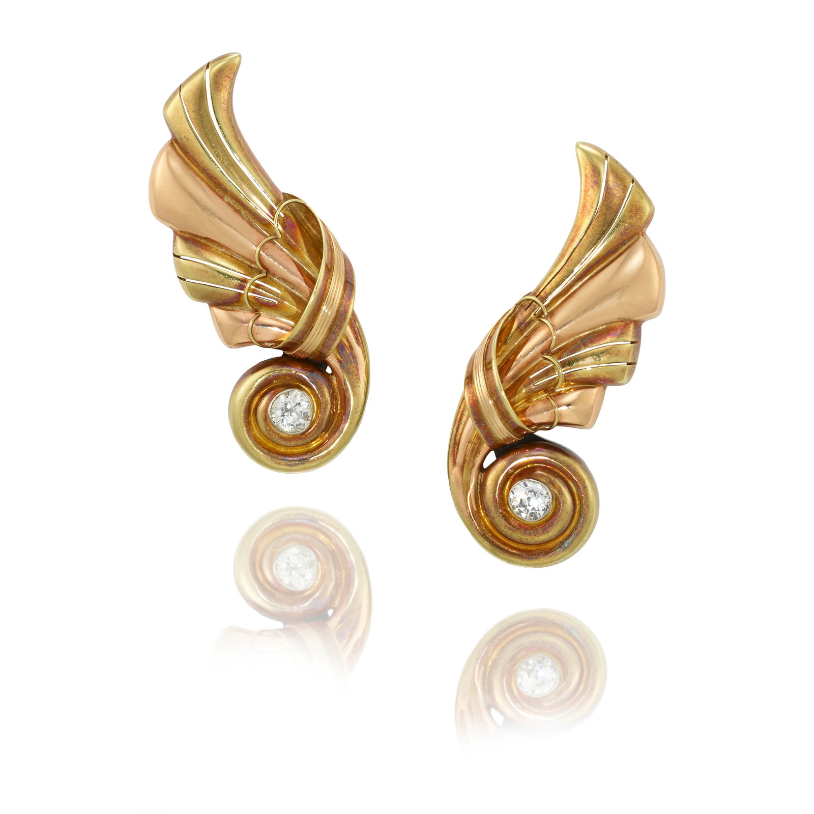 A PAIR OF BICOLOR GOLD AND DIAMOND EARCLIPS, CIRCA 1940: A PAIR OF BICOLOR GOLD AND DIAMOND EARCLIPS, CIRCA 1940 Each of fluted design, accented with old European and old mine-cut diamonds; estimated diamond weights 0.50 carats and 0.55 carats, respectively