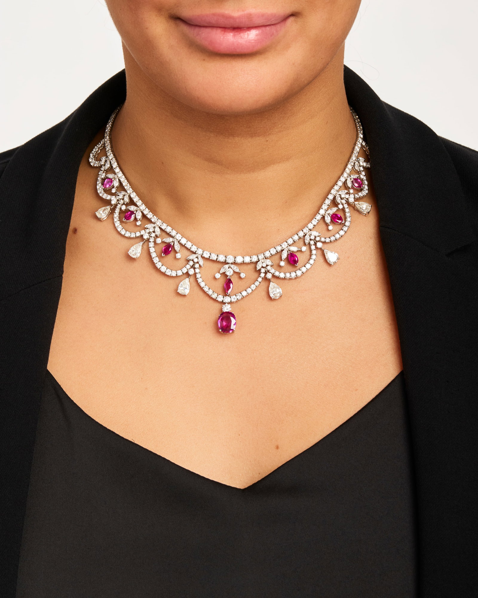 A DIAMOND, PINK SAPPHIRE AND RUBY NECKLACE: A DIAMOND, PINK SAPPHIRE AND RUBY NECKLACE Of openwork design, the center drop an oval-shaped pink sapphire weighing 3.77 carats, comprising scalloped rows of round brilliant-cut diamonds,