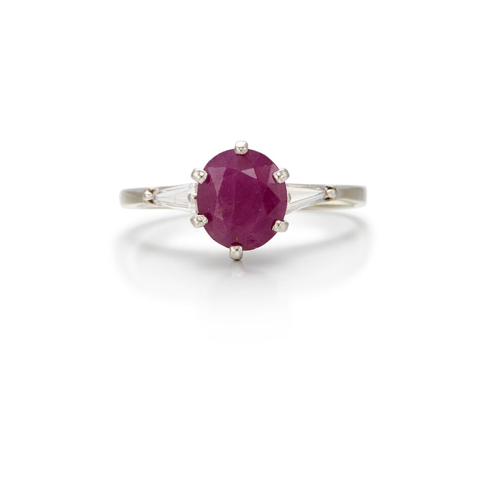 18K WHITE GOLD, RUBY AND DIAMOND RING: 18K WHITE GOLD, RUBY AND DIAMOND RING • One oval shaped ruby weighing approximately 1.77 carats total • Two tapered baguette diamonds weighing approximately 0.22 carat total • Size 6