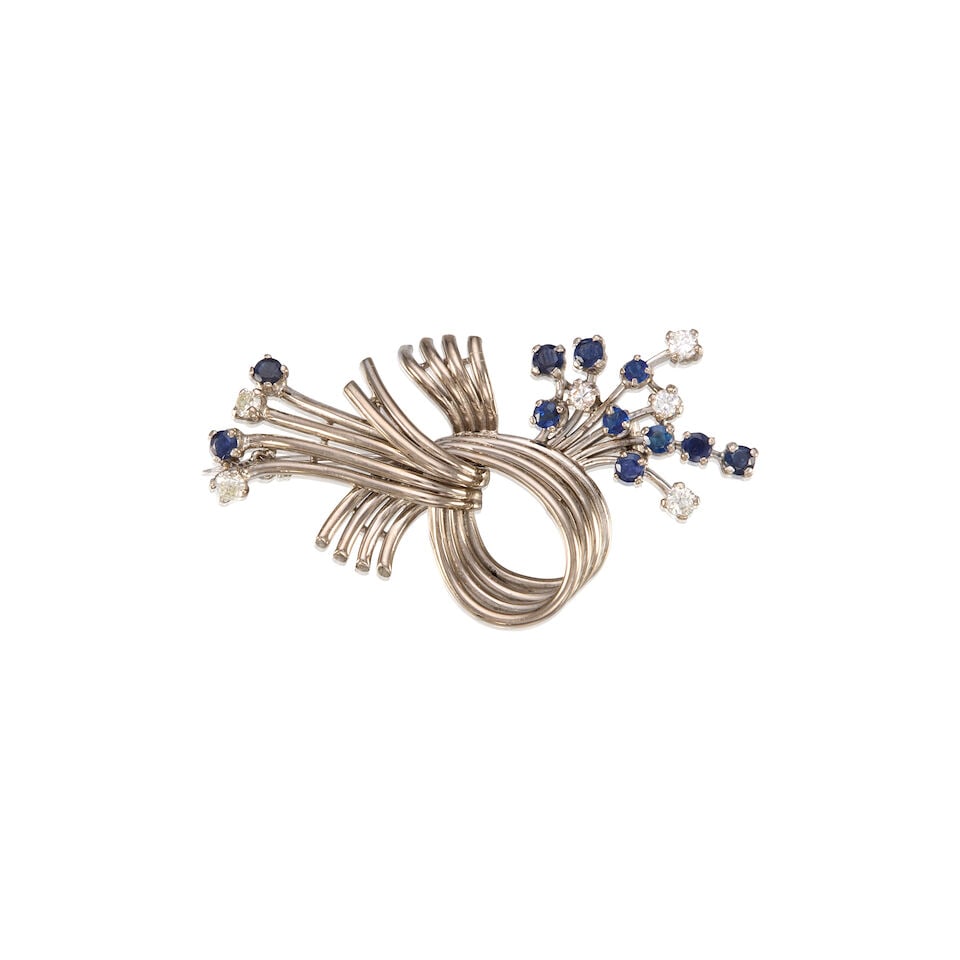 SAPPHIRE AND DIAMOND BROOCH: SAPPHIRE AND DIAMOND BROOCH • White precious metal alloy composed primarily of palladium with minor silver and gold • Eleven round shaped sapphire weighing approximately 0.79 carat total