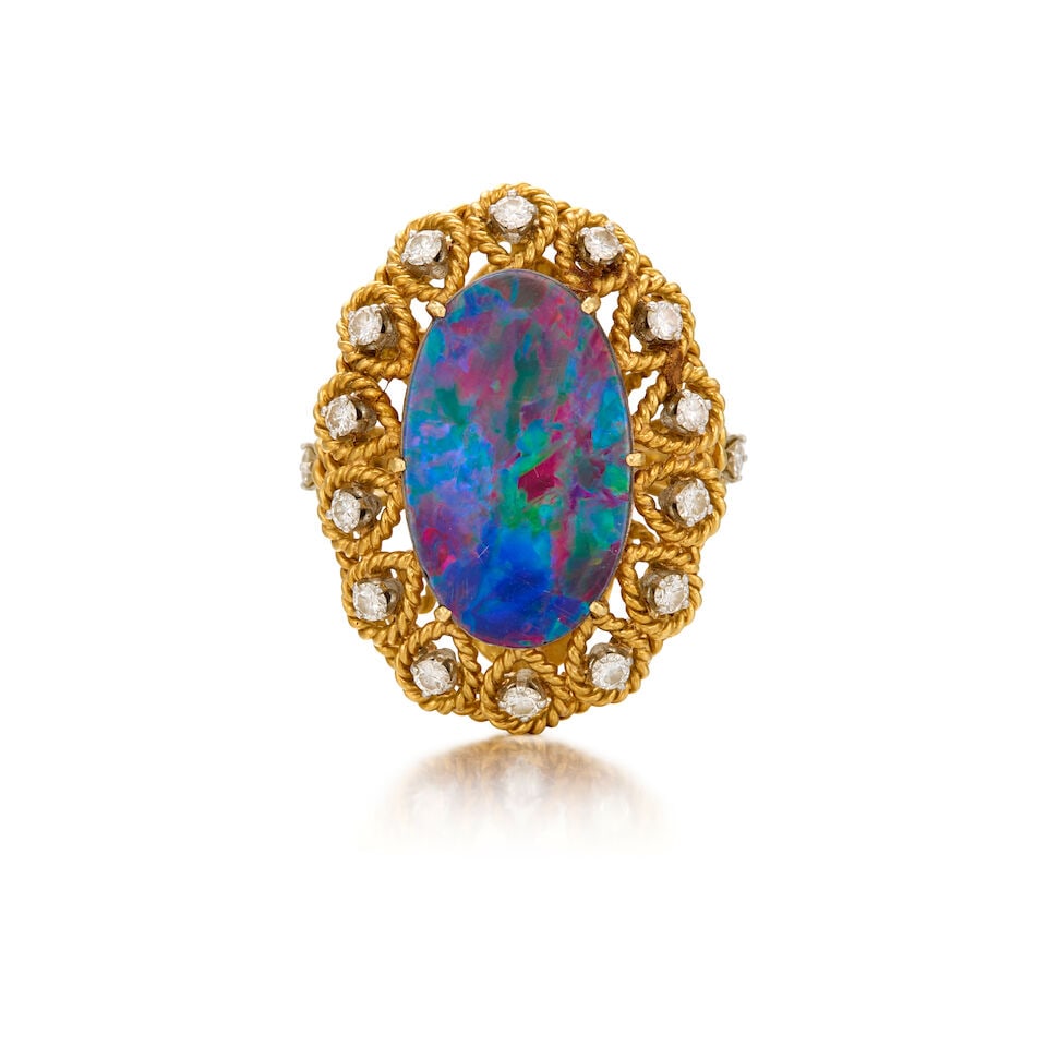 RAYMOND YARD: A 18K YELLOW GOLD, OPAL DOUBLET, AND DIAMOND RING, CIRCA 1940: RAYMOND YARD: A 18K YELLOW GOLD, OPAL DOUBLET, AND DIAMOND RING, CIRCA 1940 • An oval shaped opal doublet measuring approximately 19.99mm x 13.04mm x 3.55mm • Sixteen round shaped