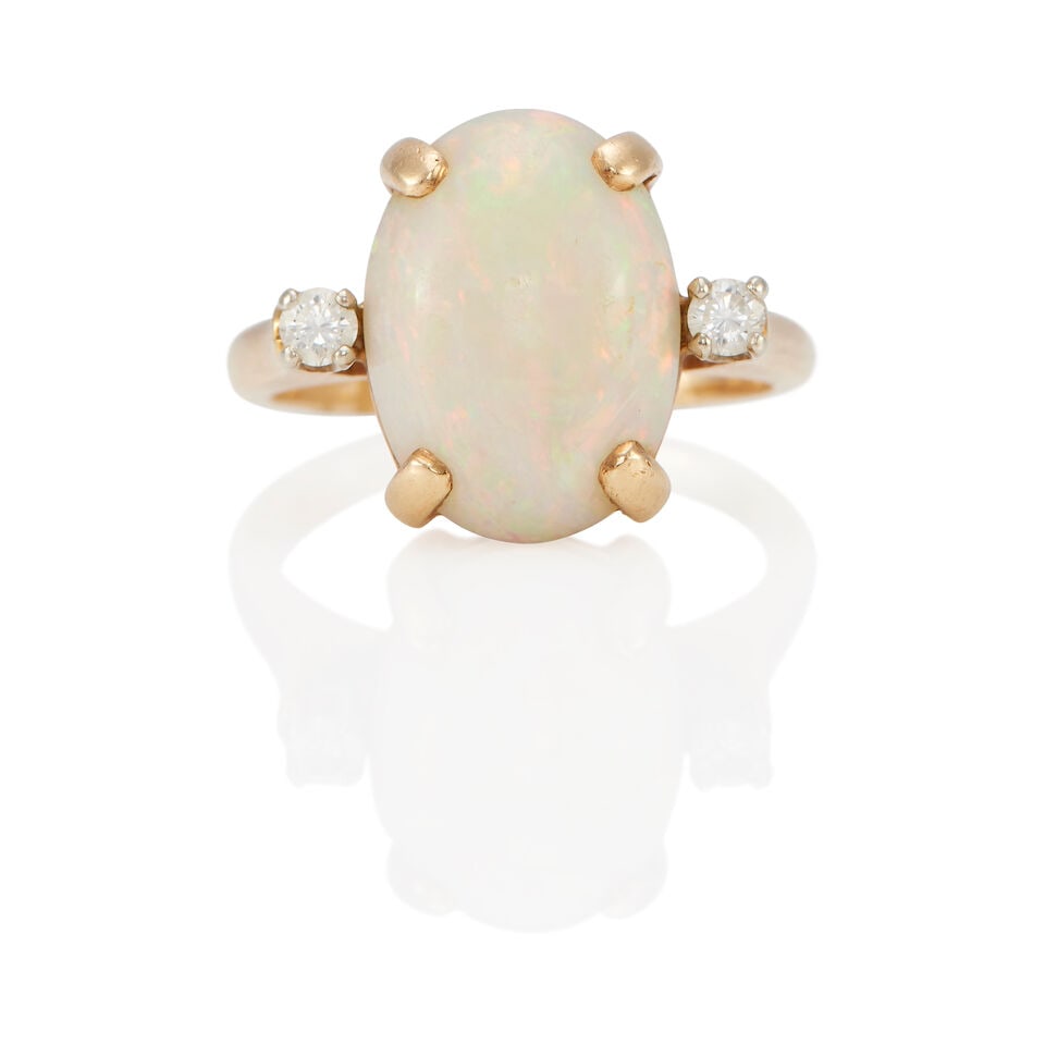 A 14K YELLOW GOLD, OPAL AND DIAMOND RING: A 14K YELLOW GOLD, OPAL AND DIAMOND RING • An opal cabochon measuring approximately 14.18mm x 10.94mm x 4.72mm • Two round shaped diamonds weighing approximately 0.08 carat total •