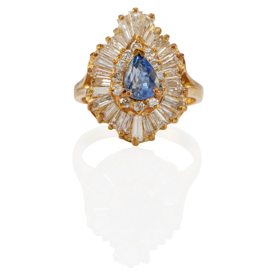 14K YELLOW GOLD, SYNTHETIC SAPPHIRE, AND DIAMOND RING: 14K YELLOW GOLD, SYNTHETIC SAPPHIRE, AND DIAMOND RING • A pear-shaped synthetic sapphire weighing approximately 0.75 carat • Twelve round shaped diamonds weighing approximately 0.12 carat