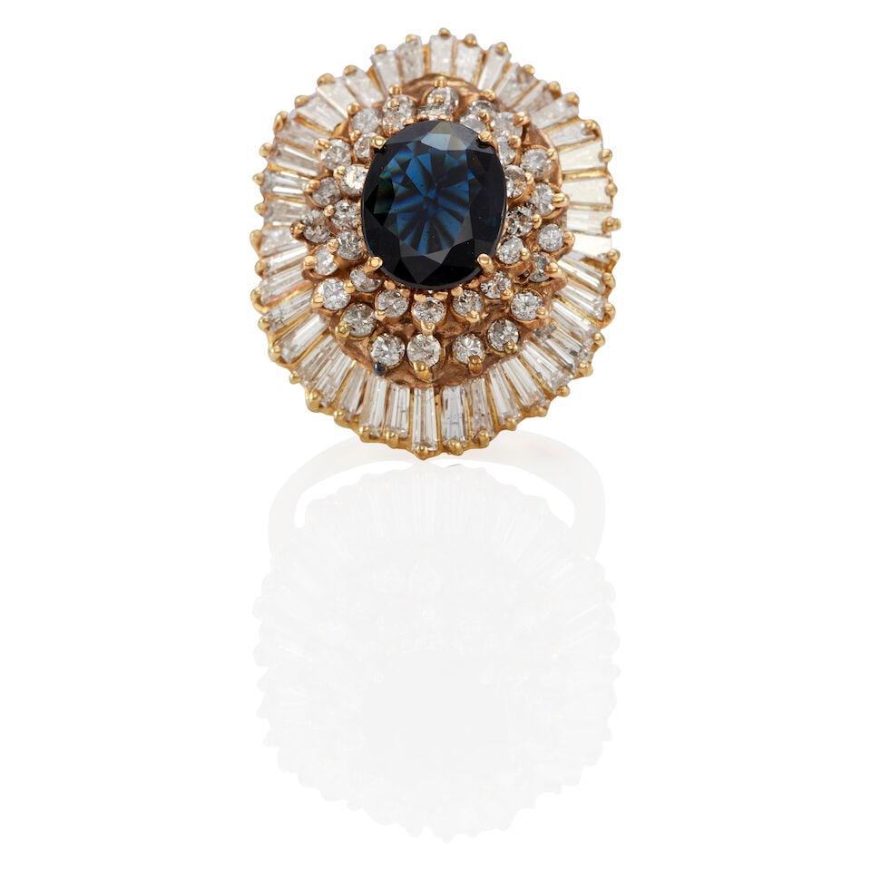 A 14K YELLOW GOLD, SAPPHIRE AND DIAMOND RING: A 14K YELLOW GOLD, SAPPHIRE AND DIAMOND RING • An oval shaped sapphire weighing approximately 2.35 carats • Numerous round and tapered baguette-cut diamonds weighing approximately 1.40