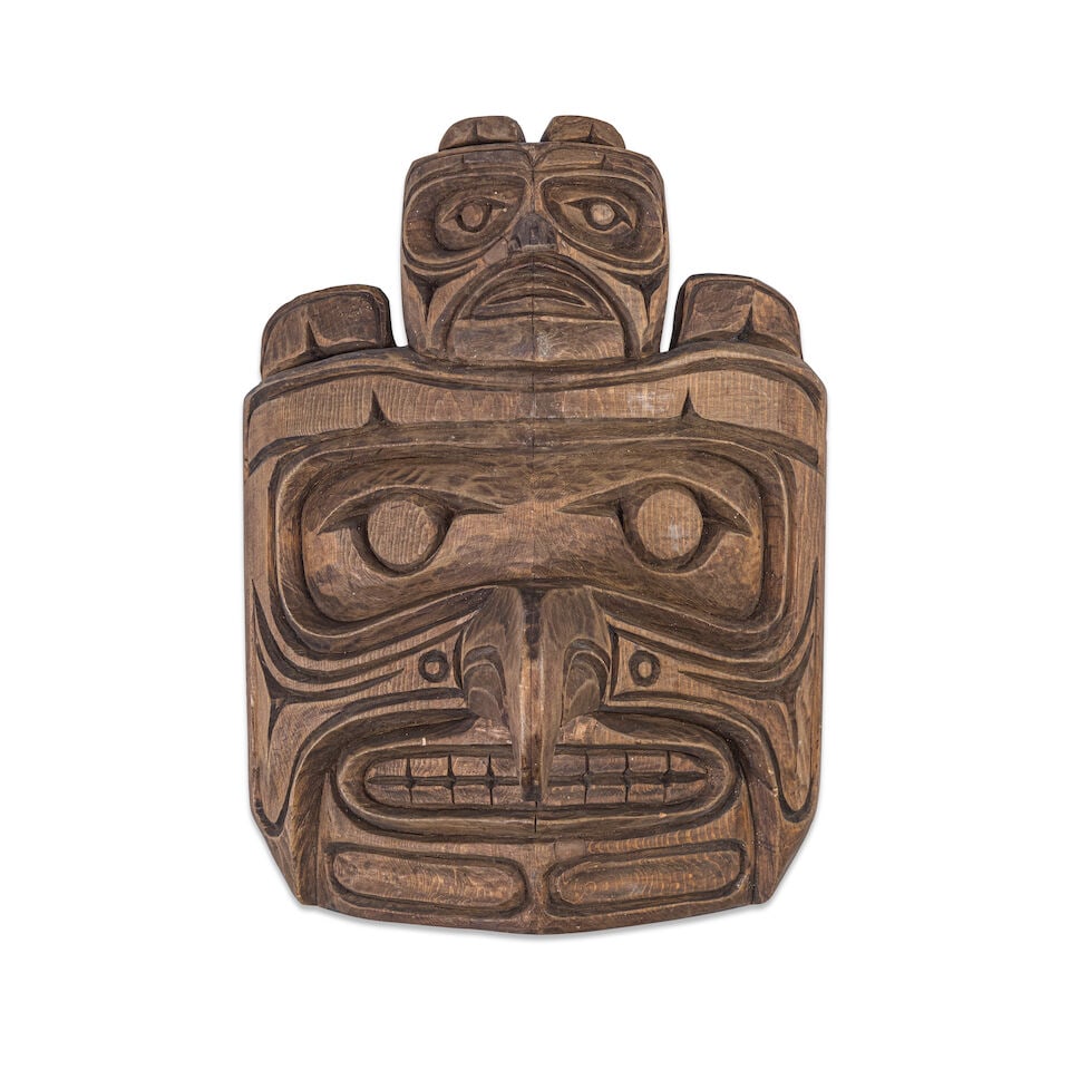 A Titus Oenga wall mask: Titus Oenga Alaska, (1938-1984), carved as a formline raven surmounted by a raven maskette, apparently unsigned. height 13in, width 9 1/2in Lot to be sold without reserve. This lot is subject to the