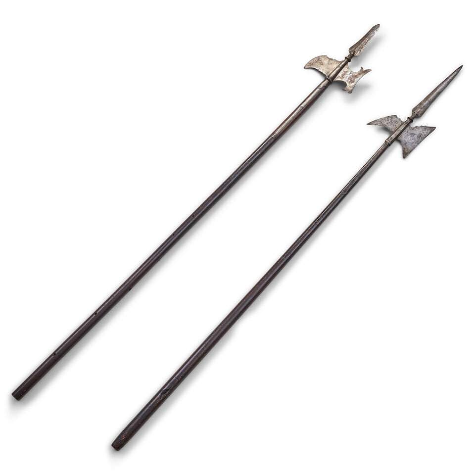 TWO 18TH CENTURY HALBERDS.: TWO 18TH CENTURY HALBERDS. The heads with double-edge pike blade above a crescent blade and beak in a tapering socket with straps secured to the poles by screws (possibly later poles, one head