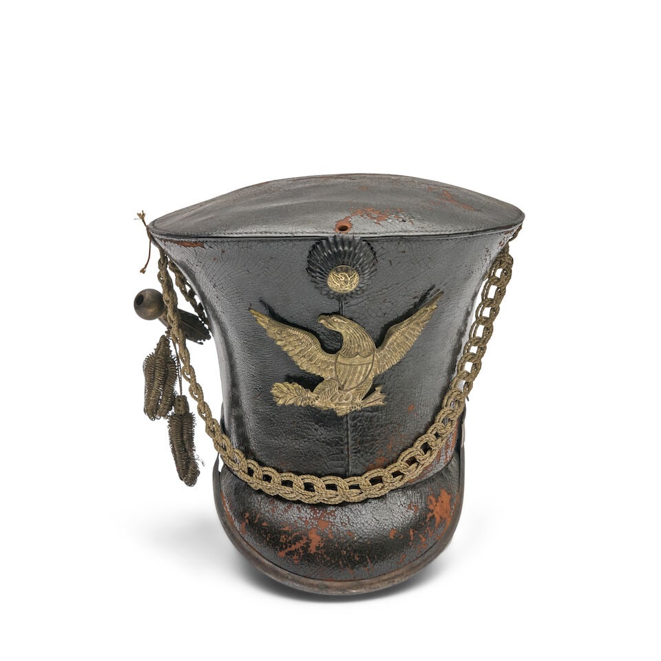 AN AMERICAN MILITARY BELL CROWNED CAP,: AN AMERICAN MILITARY BELL CROWNED CAP, William Boyd, Taunton, Massachusetts, c. 1830. Black leather body centering a pressed leather cockade above an embossed silvered brass eagle, braided silver cord