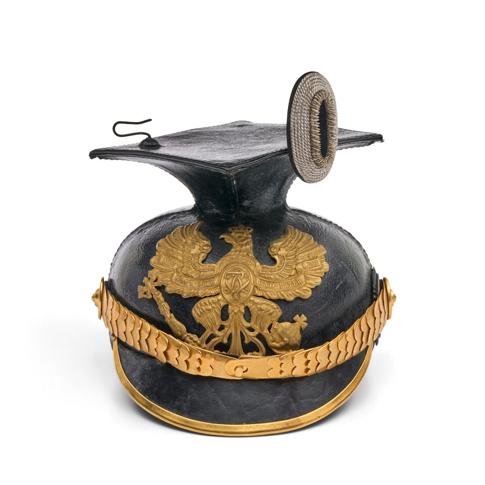 AN IMPERIAL GERMAN MODEL 1889 ULANAN (LANCER) OFFICER'S TSCHAPKA.: AN IMPERIAL GERMAN MODEL 1889 ULANAN (LANCER) OFFICER'S TSCHAPKA. Black leather square top with a silver cord badge above a rounded cap with a brass eagle plate, brass scale chin strap, cloth liner an