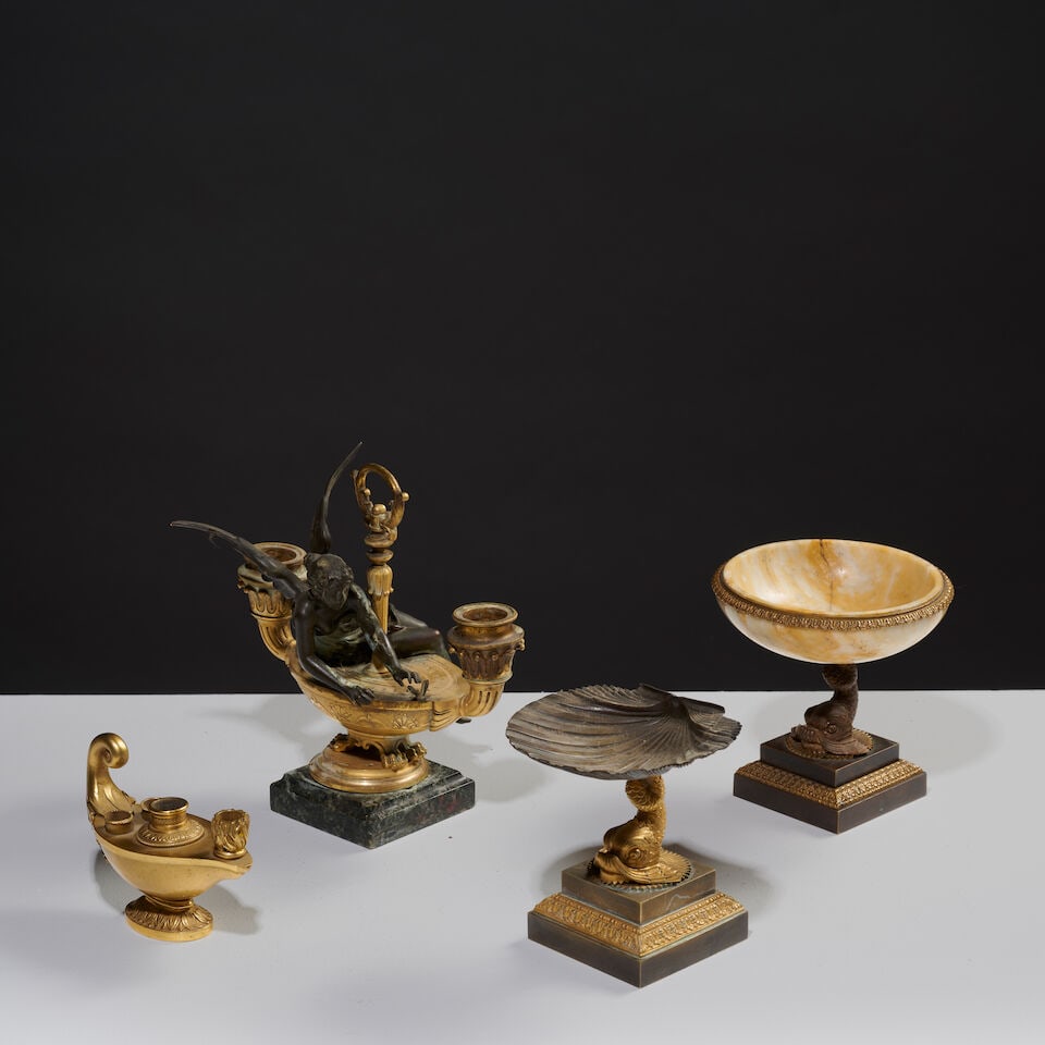 Ensemble de quatre objets en bronze doré du XIXe siècle A set of four 19th-century gil...: Ensemble de quatre objets en bronze doré du XIXe siècle A set of four 19th-century gilded and patinated bronze objects Deux petites coupes soutenues par un dauphin sur une base carrée