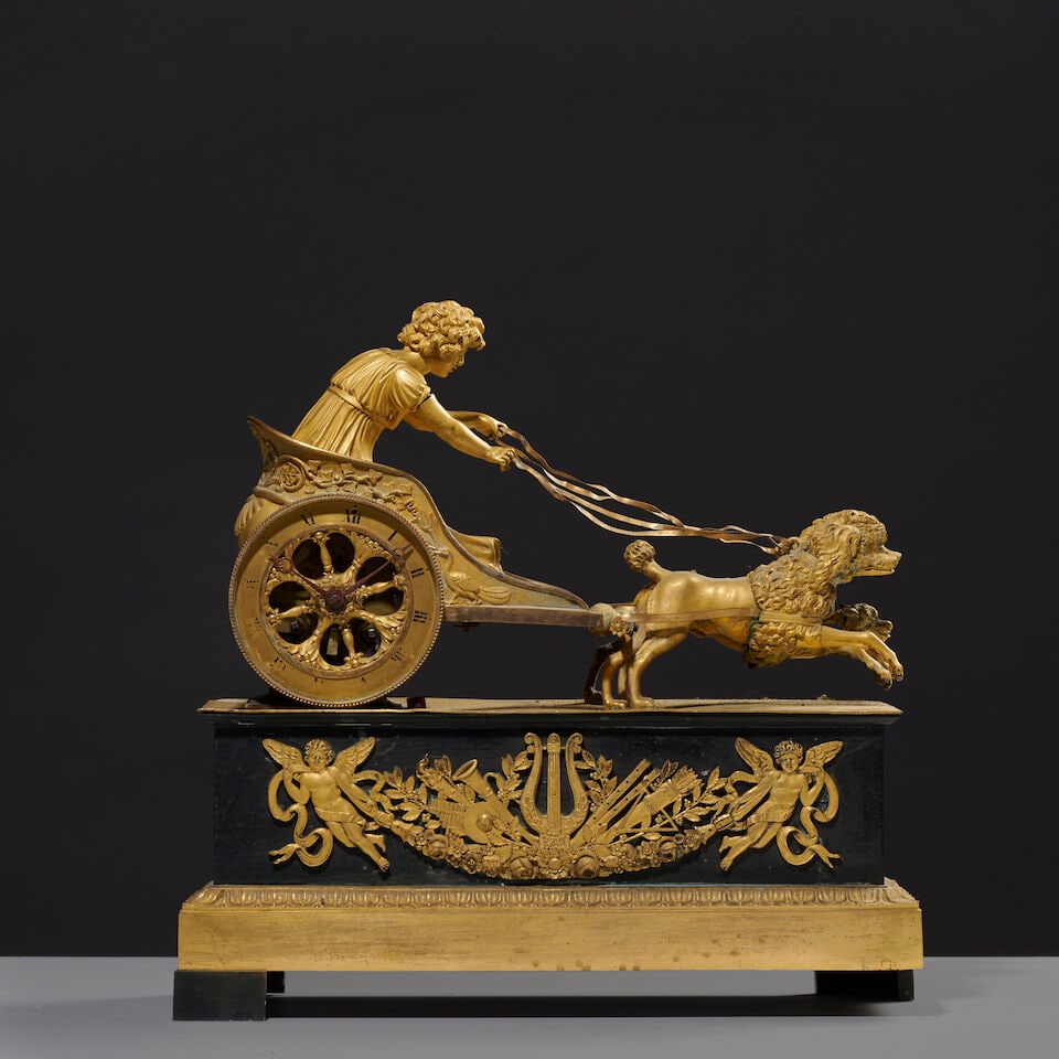 Pendule au char tirée par deux caniches en bronze patiné et doré d'époque Em...: Pendule au char tirée par deux caniches en bronze patiné et doré d'époque Empire An Empire patinated and gilt-bronze clock depicting a chariot drawn by two poodles Le char