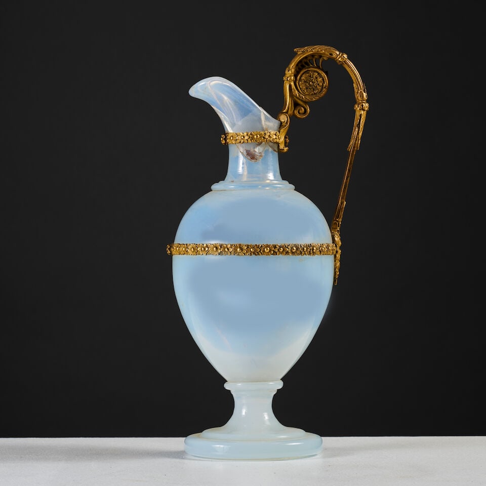 Aiguière en verre opalin laiteux et monture en bronze doré et ciselé d'époqu...: Aiguière en verre opalin laiteux et monture en bronze doré et ciselé d'époque Restauration A milky opaline glass ewer with gilt-bronze mounts, first half of the 19th