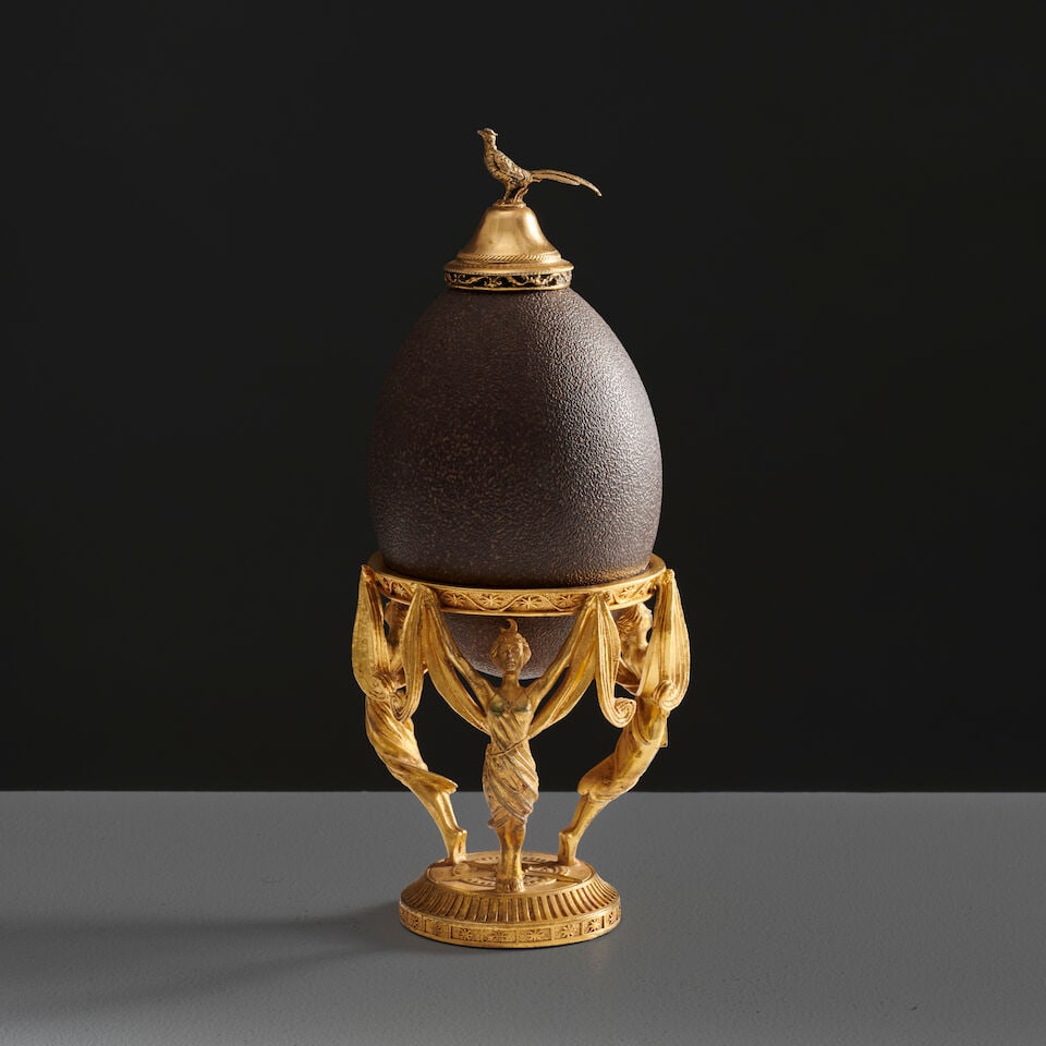 Oeuf d'émeu sur une monture en bronze doré et ciselé, probablement Angleterre, ve...: Oeuf sur une monture en bronze doré et ciselé, probablement Angleterre, vers 1890-1910 An egg on a gilt-bronze mount, probably England, circa 1890-1910 11cm in diameter, 25cm high (4in in