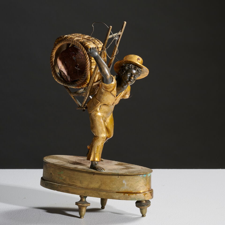 Petite pendule Le porteur de la balle de coton en bronze doré et bronze patiné du XIXe...: Petite pendule Le porteur de la balle de coton en bronze doré et bronze patiné du XIXe siècle A 19th century small clock Le porteur de la balle de coton in patinated and gilt-bronze,