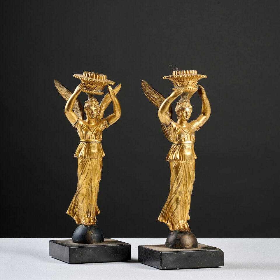 Paire de flambeaux en bronze doré et ciselé à décor de Victoire ailée, ...: Paire de flambeaux en bronze doré et ciselé à décor de Victoire ailée, XIXe siècle A pair of gilt-bronze candlesticks with winged Victory decoration, 19th century Demi