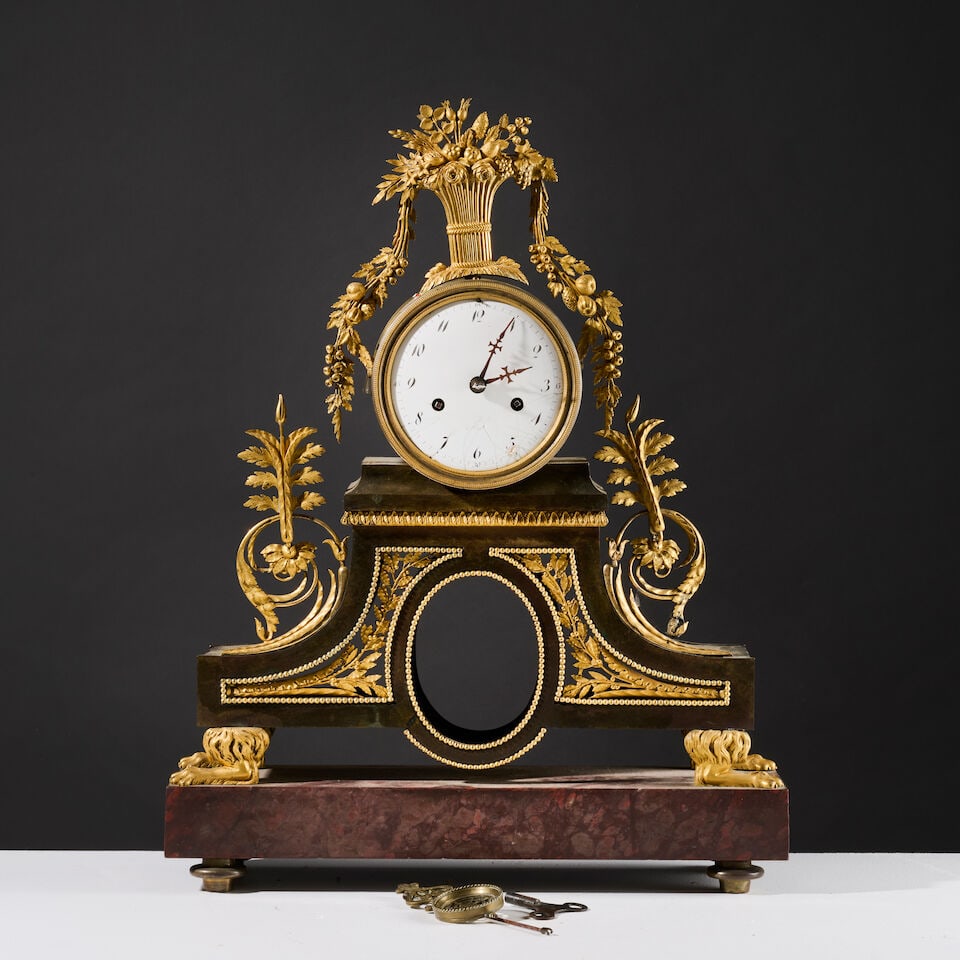 Pendule en bronze doré le mouvement circulaire sur arche d'époque Directoire A Directo...: Pendule en bronze doré le mouvement circulaire sur arche d'époque Directoire A Directoire gilt-bronze clock with a circular movement set on an arch Le cadran, émaillé blanc à