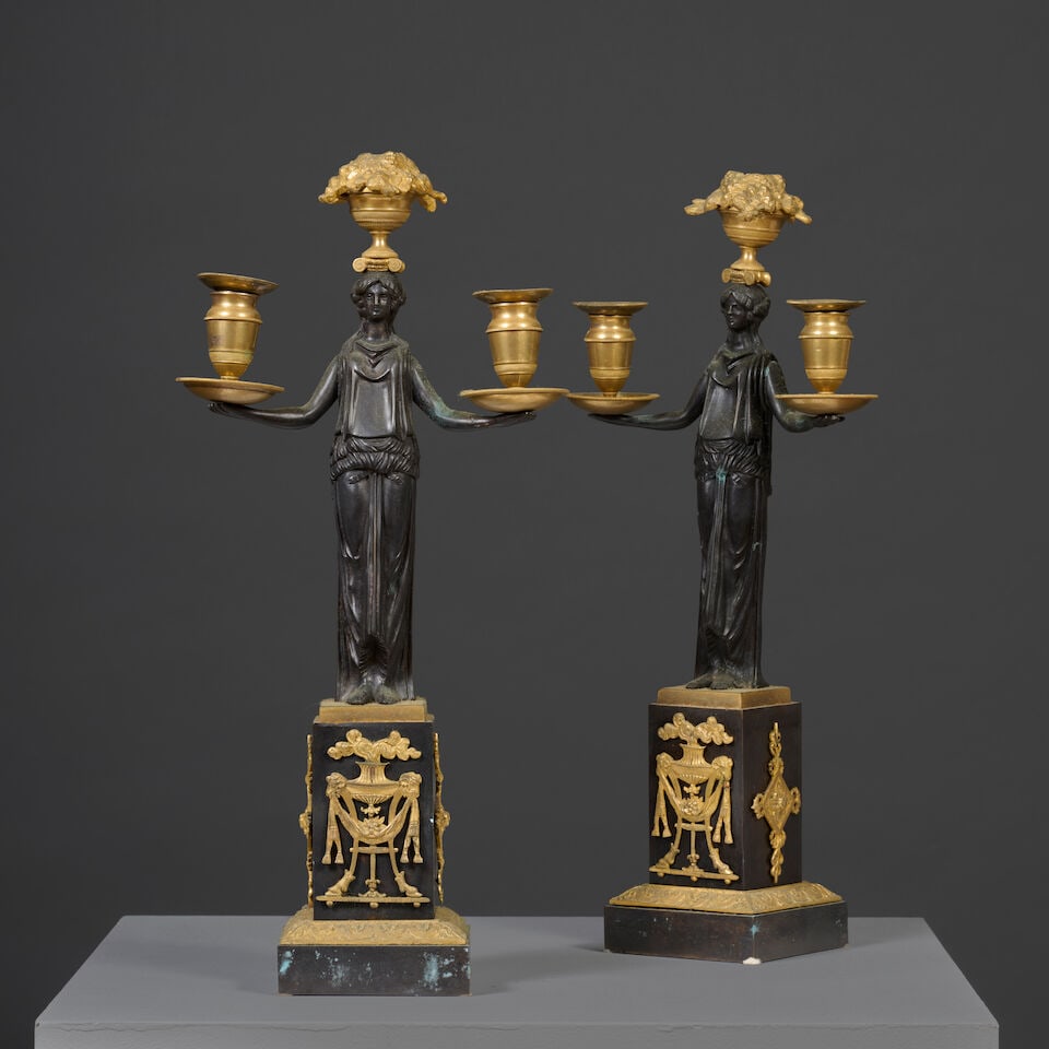 Paire de candélabres en bronze patiné et doré à trois lumières soutenue...: Paire de candélabres en bronze patiné et doré à trois lumières soutenues par une vestale d'époque Empire An pair of three-light candelabra in gilt and patinated bronze