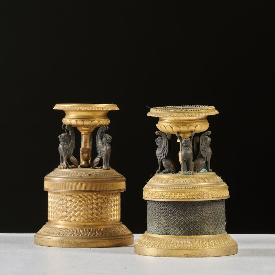 Deux supports en forme de coupe surpportée par trois lions ailés en bronze doré e...: Deux supports en forme de coupe surpportée par trois lions ailés en bronze doré et patiné d'époque Restauration Two supports in the form of bowls supported by three winged