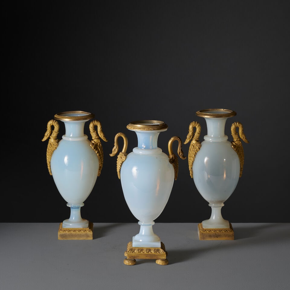 Trois vases de forme ovoïde en opaline laiteuse et monture en bronze doré et cisel...: Trois vases de forme ovoïde en opaline laiteuse et monture en bronze doré et ciselé d'époque Restauration Three ovoid vase in milky opaline glass with a chased gilt-bronze mount, f