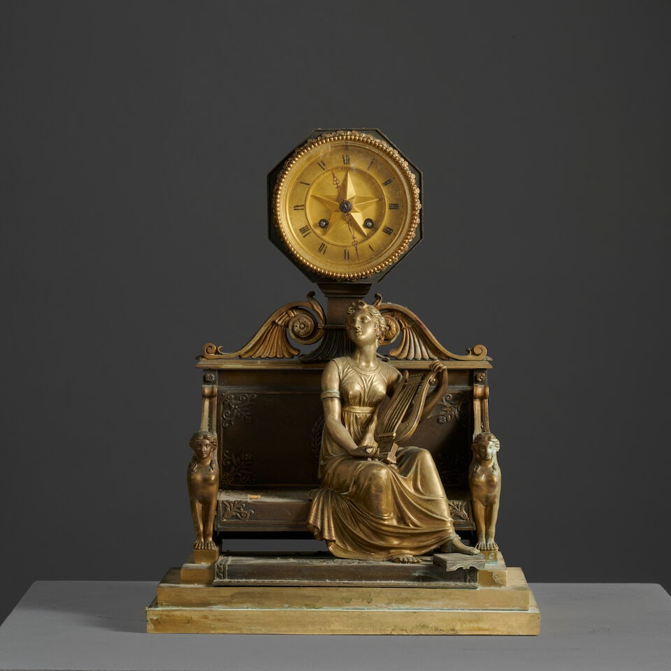 Pendule figurant Terpsychore en bronze doré et patiné d'époque Empire A Empire c...: Pendule figurant Terpsychore en bronze doré et patiné d'époque Empire A Empire clock depicting Terpsichore in gilt and patinated bronze La Muse est assise sur un sofa dont le dossier su