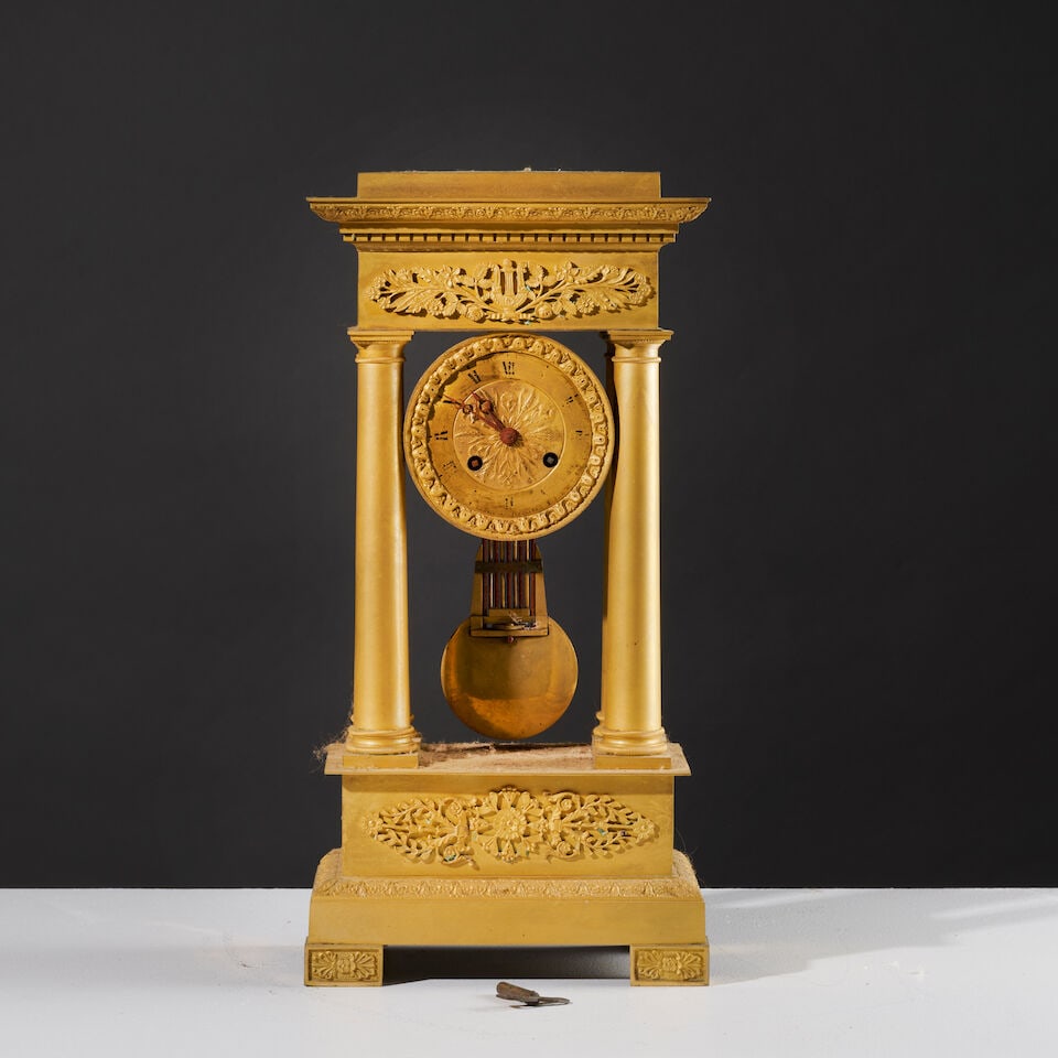 Pendule portique en bronze doré et ciselé d'époque Restauration A portico clock i...: Pendule portique en bronze doré et ciselé d'époque Restauration A portico clock in gilt-bronze, first half of the 19th century La cadran entouré d'une guirlande de fleurs est reten