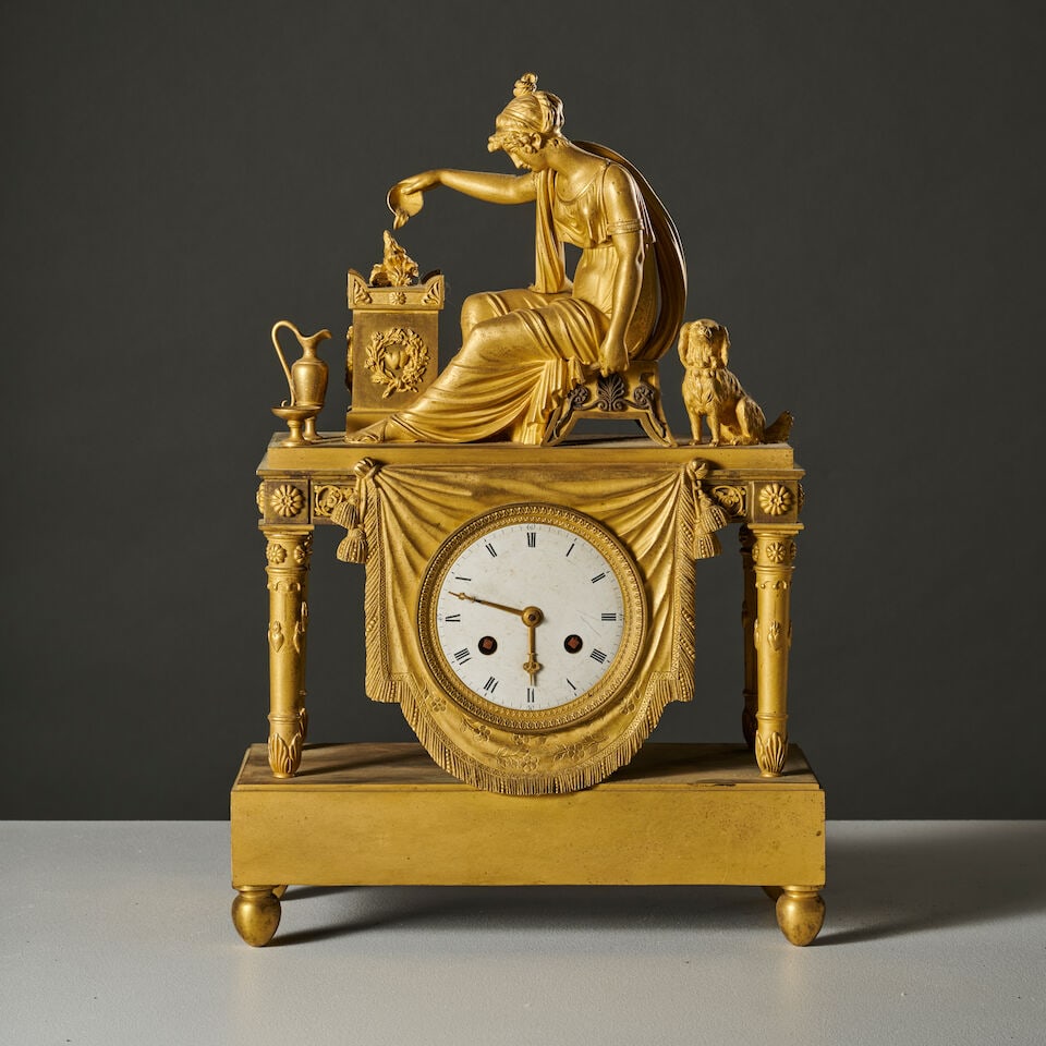 Pendule en bronze doré et ciselé figurant une femme et son chien symbilisant la fid...: Pendule en bronze doré et ciselé figurant une femme et son chien symbilisant la fidélité d'époque Empire A gilt-bronze clock depicting a woman and her dog symbolizing Fidelity