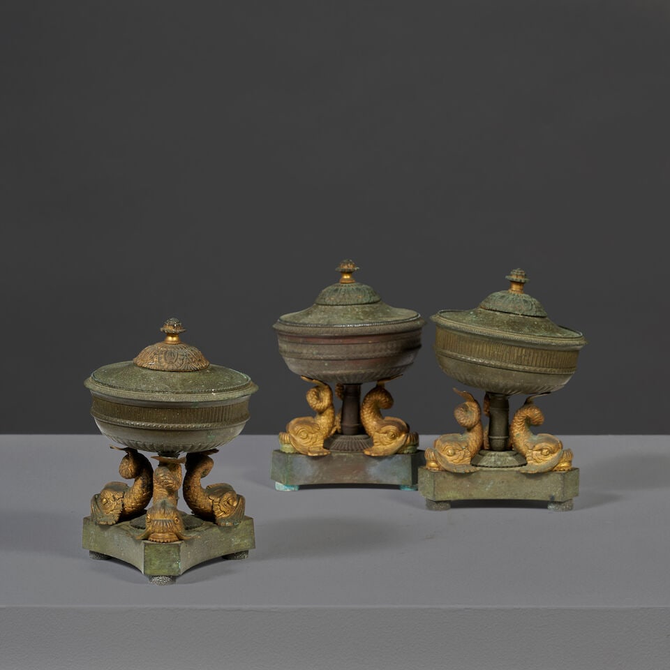 Suite de trois coupes couvertes aux dauphins en bronze patiné et doré du XIXe siè...: Suite de trois coupes couvertes aux dauphins en bronze patiné et doré du XIXe siècle A set of three covered bowls with dolphins in patinated and gilt-bronze, 19th century Le couvercle