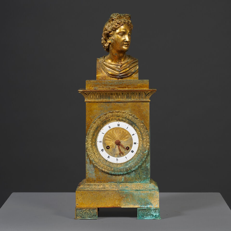 Pendule borne surmontée du buste de l'Apollon du Belvédère en bronze doré et...: Pendule borne surmontée du buste de l'Apollon du Belvédère en bronze doré et ciselé d'époque Restauration A mantel clock surmounted by the bust of the Apollo Belvedere