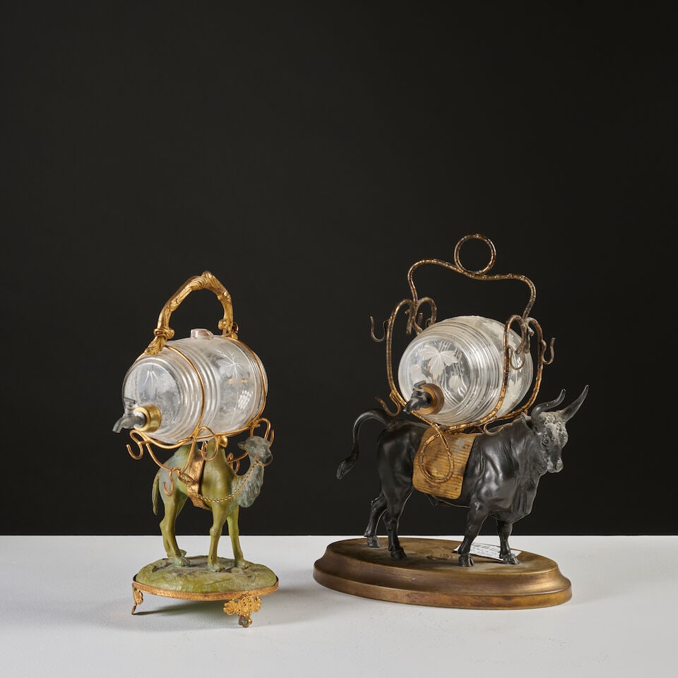 Deux caves à liqueur en forme de bovin et de dromadaire en régule à patine brune ...: Deux caves à liqueur en forme de bovin et de dromadaire en régule à patine brune et doré du XIXe siècle A 19th century two liqueur set in the form of a bovine and camel in