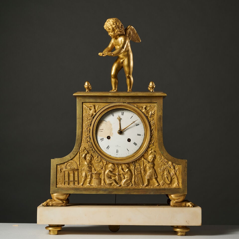 Pendule en bronze doré et ciselé à décor de scènes de putti jouants d'&...: Pendule en bronze doré et ciselé à décor de scènes de putti jouants d'époque Empire A gilt-bronze clock with decoration of scenes of playing putti, first half of the
