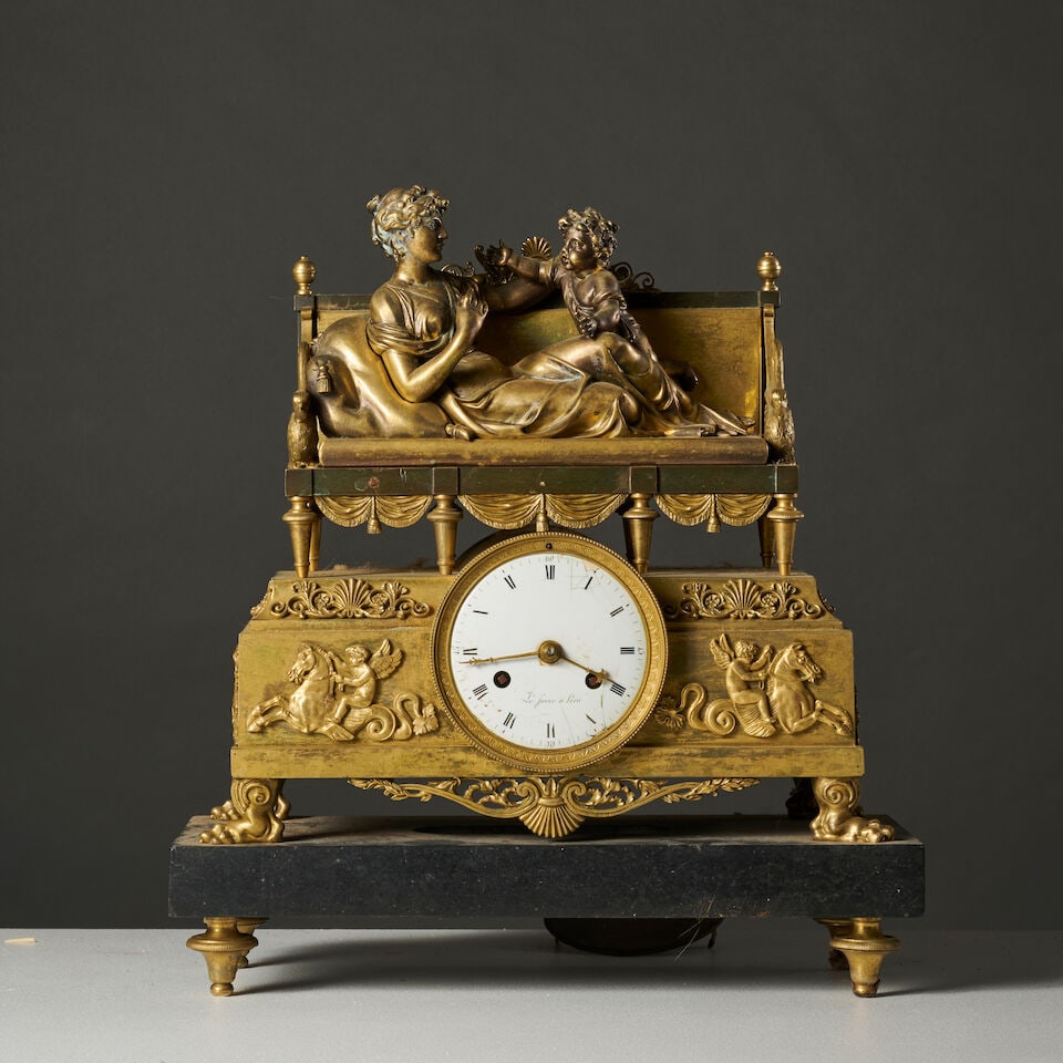 Pendule en bronze doré et ciselé figurant Aphrodite et l'Amour A chased and gilt-bronz...: Pendule en bronze doré et ciselé figurant Aphrodite et l'Amour A chased and gilt-bronze clock depicting Aphrodite and Eros Aphrodite allongée sur un sofa à col de cygne
