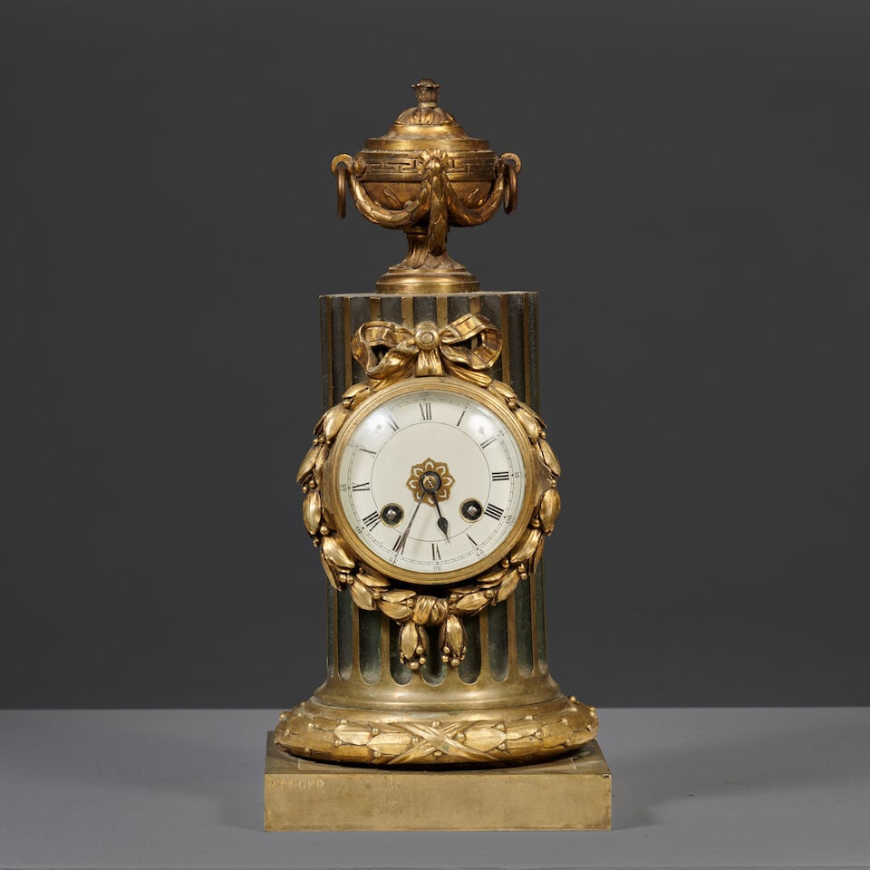 Pendule colonne surmontée d'un vase couvert en bronze doré par Osmond d'époque Lo...: Pendule colonne surmontée d'un vase couvert en bronze doré par Osmond d'époque Louis XVI A Louis XVI column clock surmounted by a covered vase in gilt-bronze by Osmond Le cadran