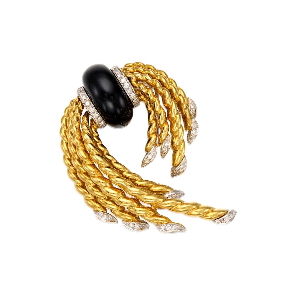 18K BICOLOR GOLD, ONYX, AND DIAMOND BROOCH, ITALIAN: 18K BICOLOR GOLD, ONYX, AND DIAMOND BROOCH, ITALIAN • 18K yellow and white gold • One free form onyx measuring approximately 19.28mm x 12.34mm • Numerous round single cut diamonds