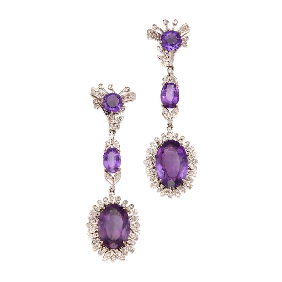 13K WHITE GOLD AMETHYST AND DIAMOND EARRINGS: 13K WHITE GOLD AMETHYST AND DIAMOND EARRINGS • Six round and oval shaped amethyst weighing approximately 28 carats total • Numerous round shaped diamonds weighing approximately 1 carat