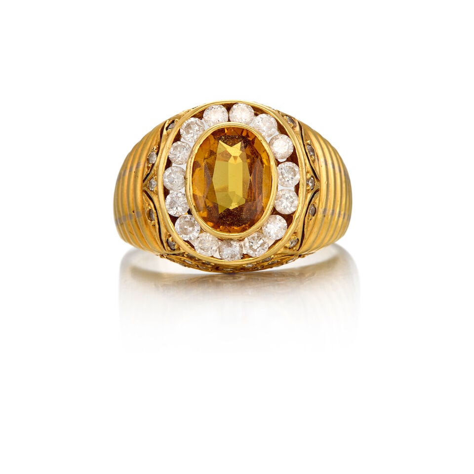 18K GOLD, SAPPHIRE AND DIAMOND RING: 18K GOLD, SAPPHIRE AND DIAMOND RING • One oval shaped orange sapphire weighing approximately 1.60 carats total • Numerous round single cut and brilliant cut diamonds weighing